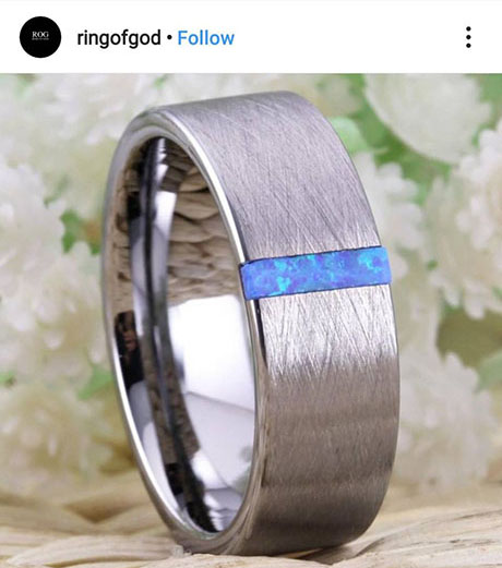 แหวนทังสเตนสีเงินเรียบหรูขัดเงามาพร้อมพลอยโอปอลสีน้ำเงินฝังตัวมาในแนวตั้งฉากกับตัวแหวน